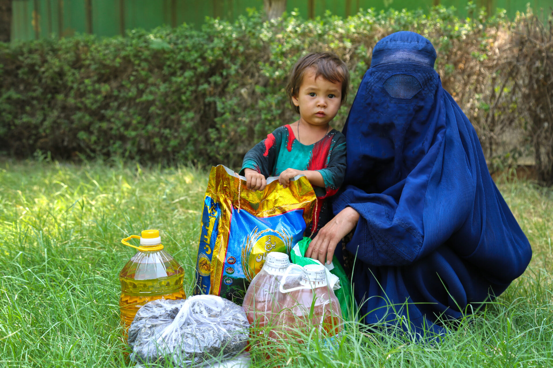 Afghan mother and child receiving emergency relief from STEP