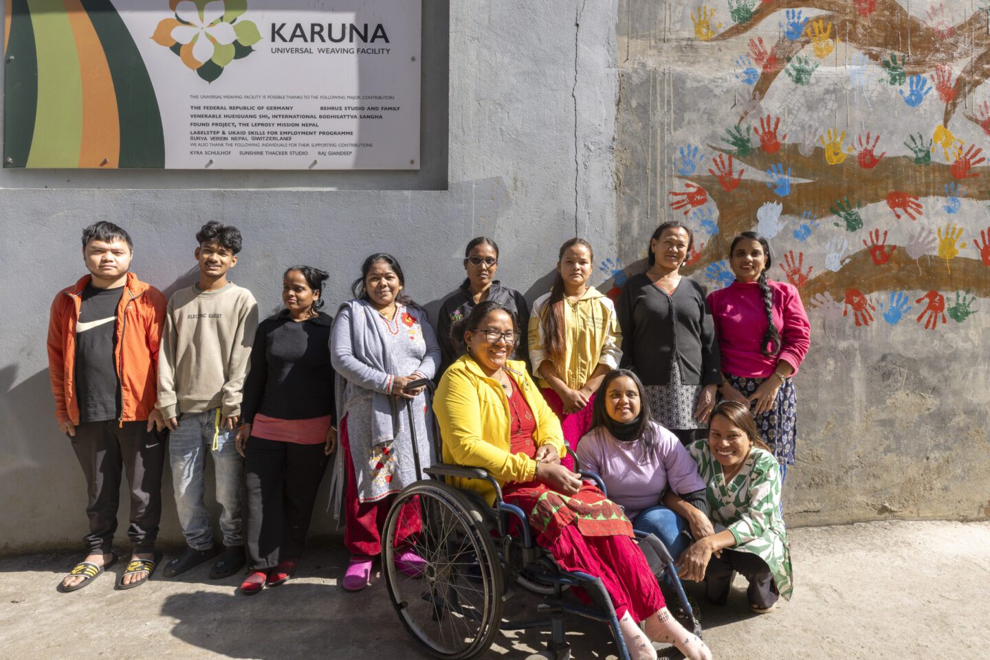 Group photo of weavers working at the Karuna Universal Weaving Facility. 